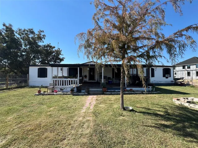 a view of a house with a yard patio and fire pit