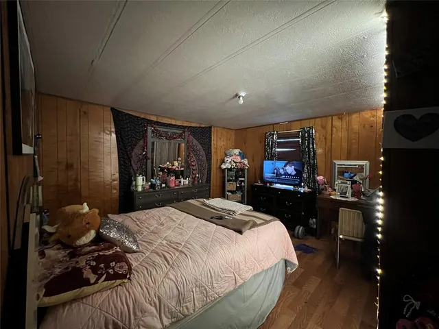 a bedroom with a bed a television and a large window