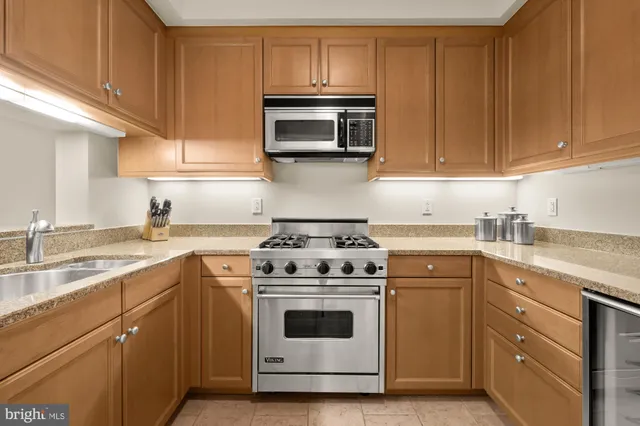 a kitchen with granite countertop white cabinets and stainless steel appliances