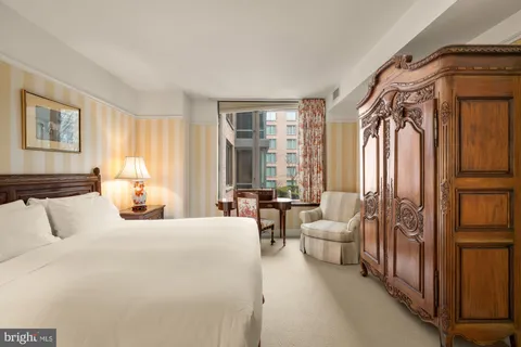 a bedroom with furniture and a large window