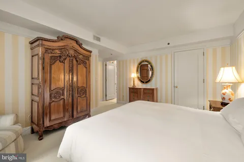 a bedroom with a bed a mirror and a closet