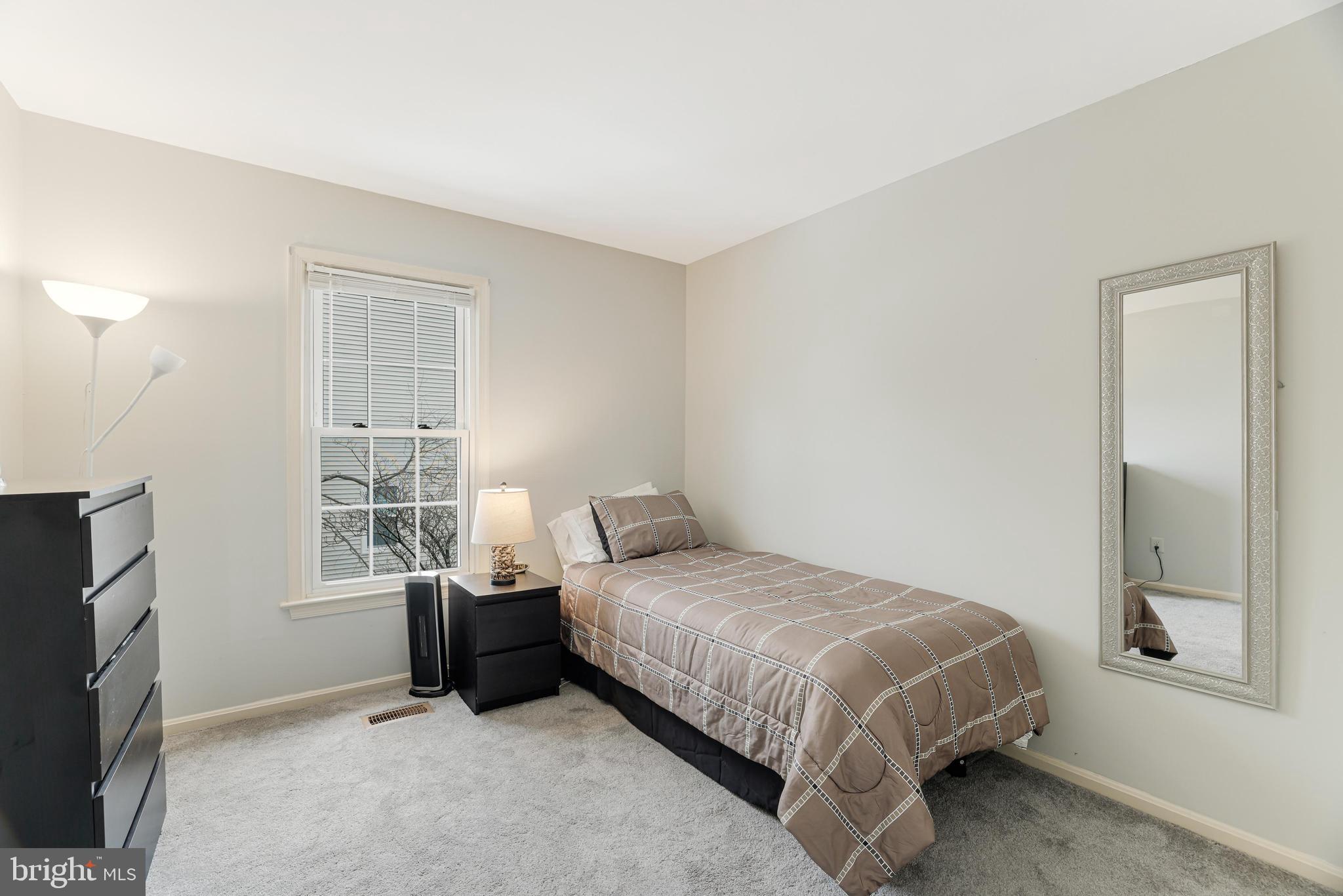 8813 Winding Hollow Way Springfield, VA 22152 - Photo 16 of 29 a bedroom with a bed and a flat tv screen on the dresser