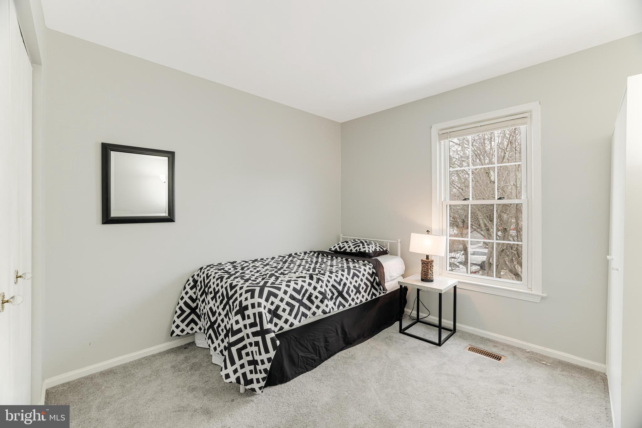 8813 Winding Hollow Way Springfield, VA 22152 - Photo 17 of 29 a bed sitting in a bedroom next to a window