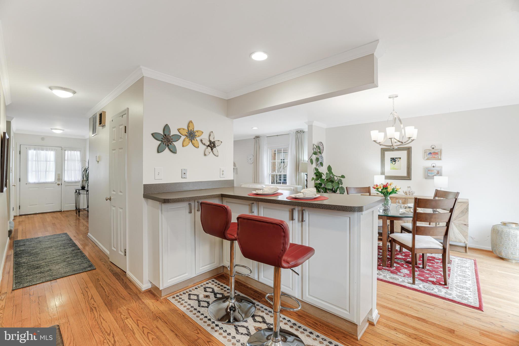 8813 Winding Hollow Way Springfield, VA 22152 - Photo 4 of 29 a view of kitchen island dining space wooden floor and dining table