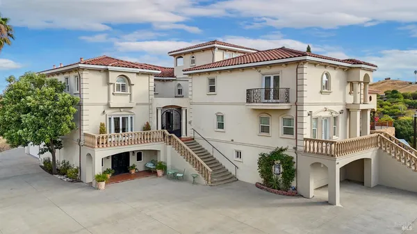 a view of a white house with large windows and a small barn