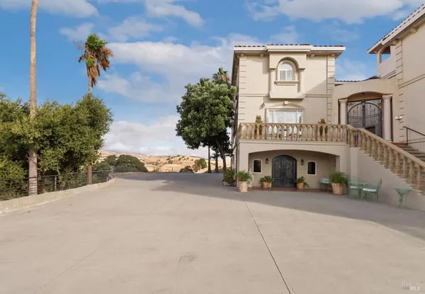 a view of a brick house with iron fence