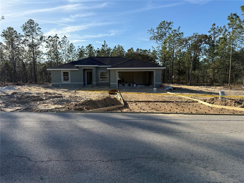 a view of a house with backyard and trees