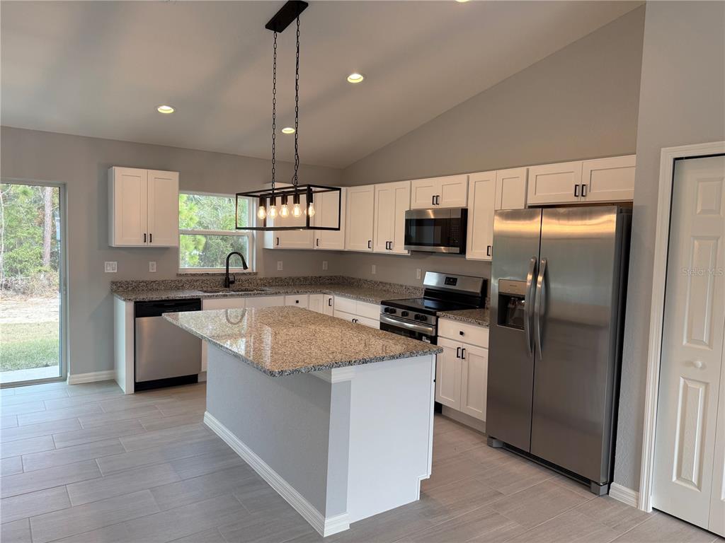2460 Northwest Buena Vista Road Dunnellon, FL 34431 - Photo 2 of 14 a kitchen with kitchen island granite countertop stainless steel appliances a sink a counter top space cabinets and a window