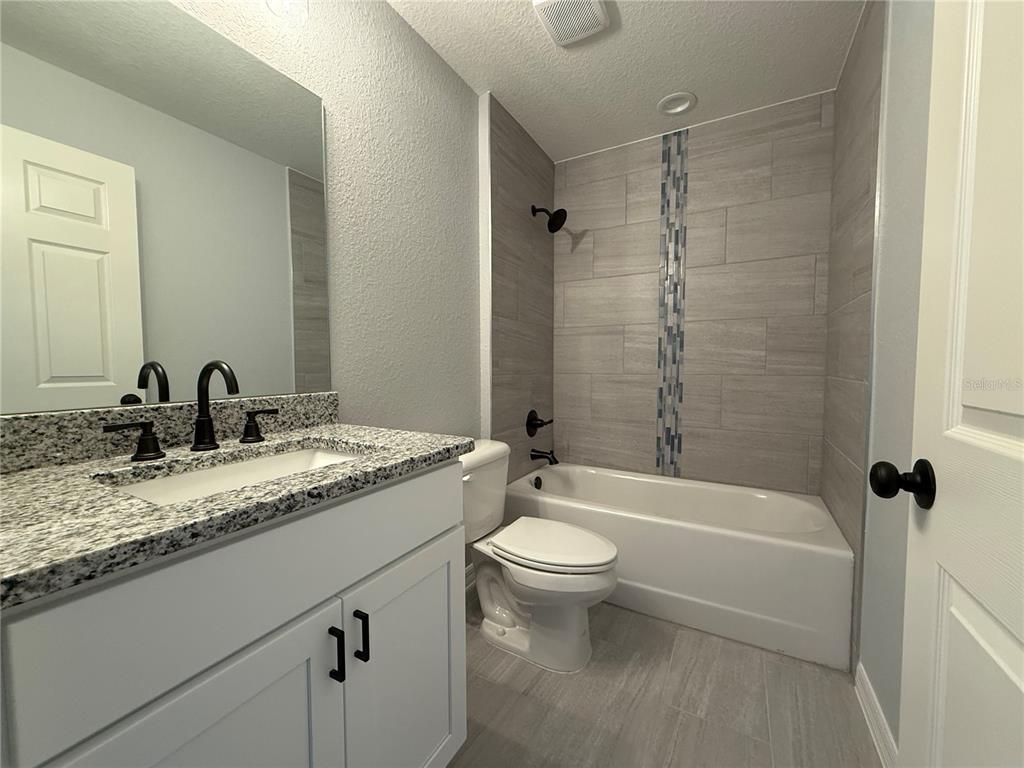2460 Northwest Buena Vista Road Dunnellon, FL 34431 - Photo 5 of 14 a bathroom with a granite countertop sink toilet mirror and bathtub