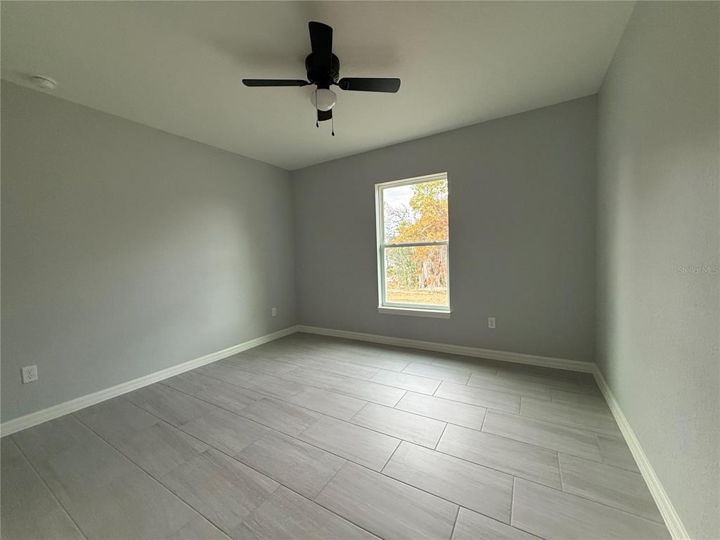 2460 Northwest Buena Vista Road Dunnellon, FL 34431 - Photo 6 of 14 an empty room with a window and a ceiling fan