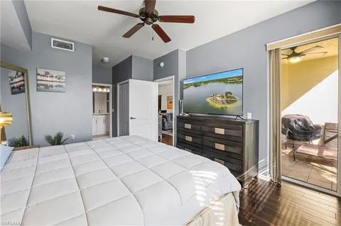 a bedroom with a bed and a flat tv screen on dresser