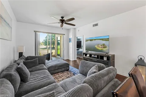 a living room with furniture a ceiling fan and a window
