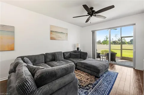a living room with furniture and a large window with wooden floor