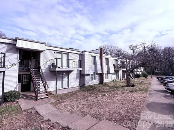 a view of residential houses with yard and wooden fence
