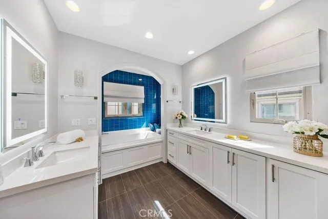a bathroom with a tub a sink and mirror