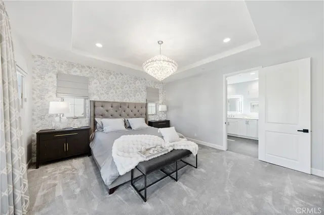 a spacious bedroom with a bed and a chandelier