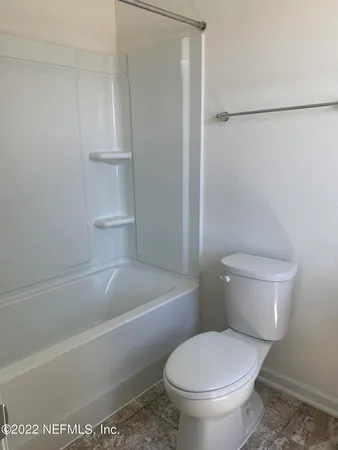 a white toilet sitting next to a bath tub