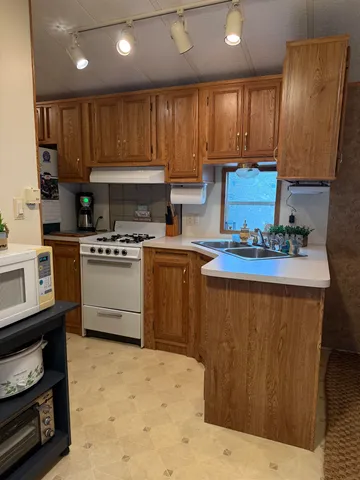 a kitchen with stainless steel appliances kitchen island granite countertop a stove sink and cabinets