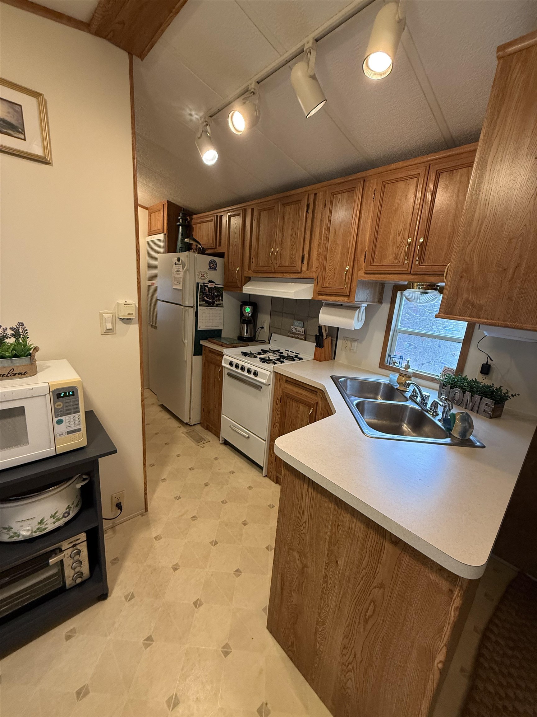 3066 Highway 9 Ocean View, NJ 08230 - Photo 22 of 22 a kitchen with wooden cabinets a sink a stove and a refrigerator