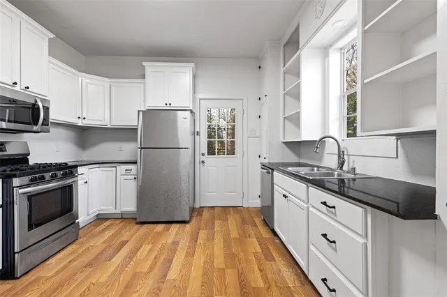 a view of empty room with wooden floor