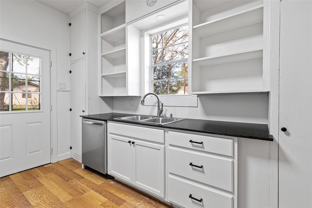 204 Jones Street Longview, TX 75602 - Photo 14 of 32 a kitchen with granite countertop white cabinets and window