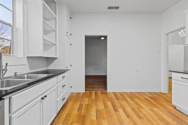 a kitchen with stainless steel appliances granite countertop a refrigerator stove and white cabinets