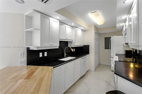 a kitchen with granite countertop a sink dishwasher stove and cabinets