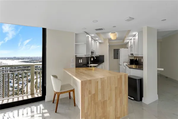 a large white kitchen with a large window