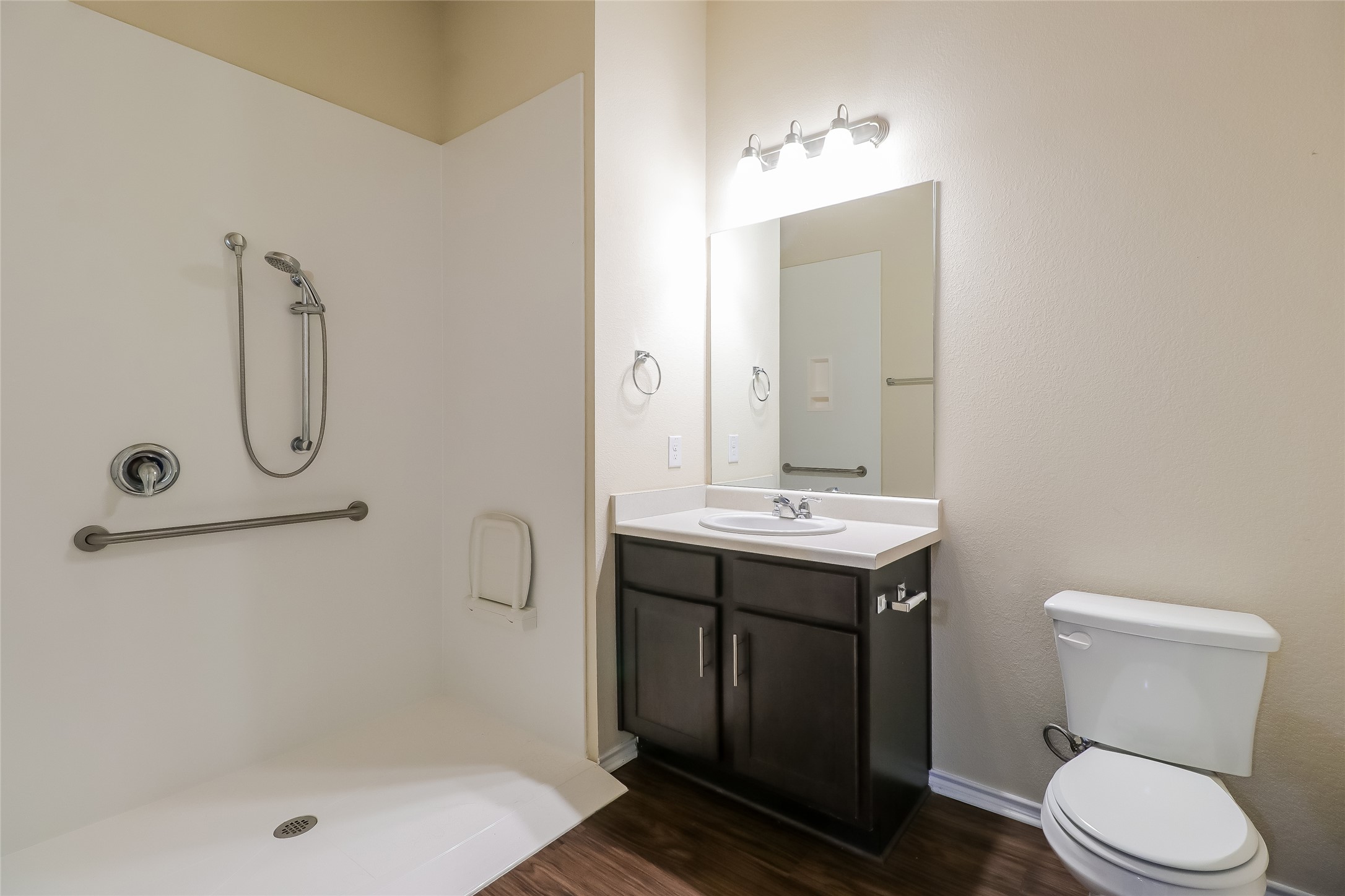 8601 West Gate Boulevard, Unit 7101 Austin, TX 78745 - Photo 14 of 16 Full bathroom with vanity, walk in shower, and dark wood-type flooring