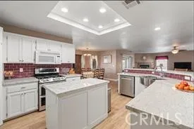 a kitchen with kitchen island a stove and a sink