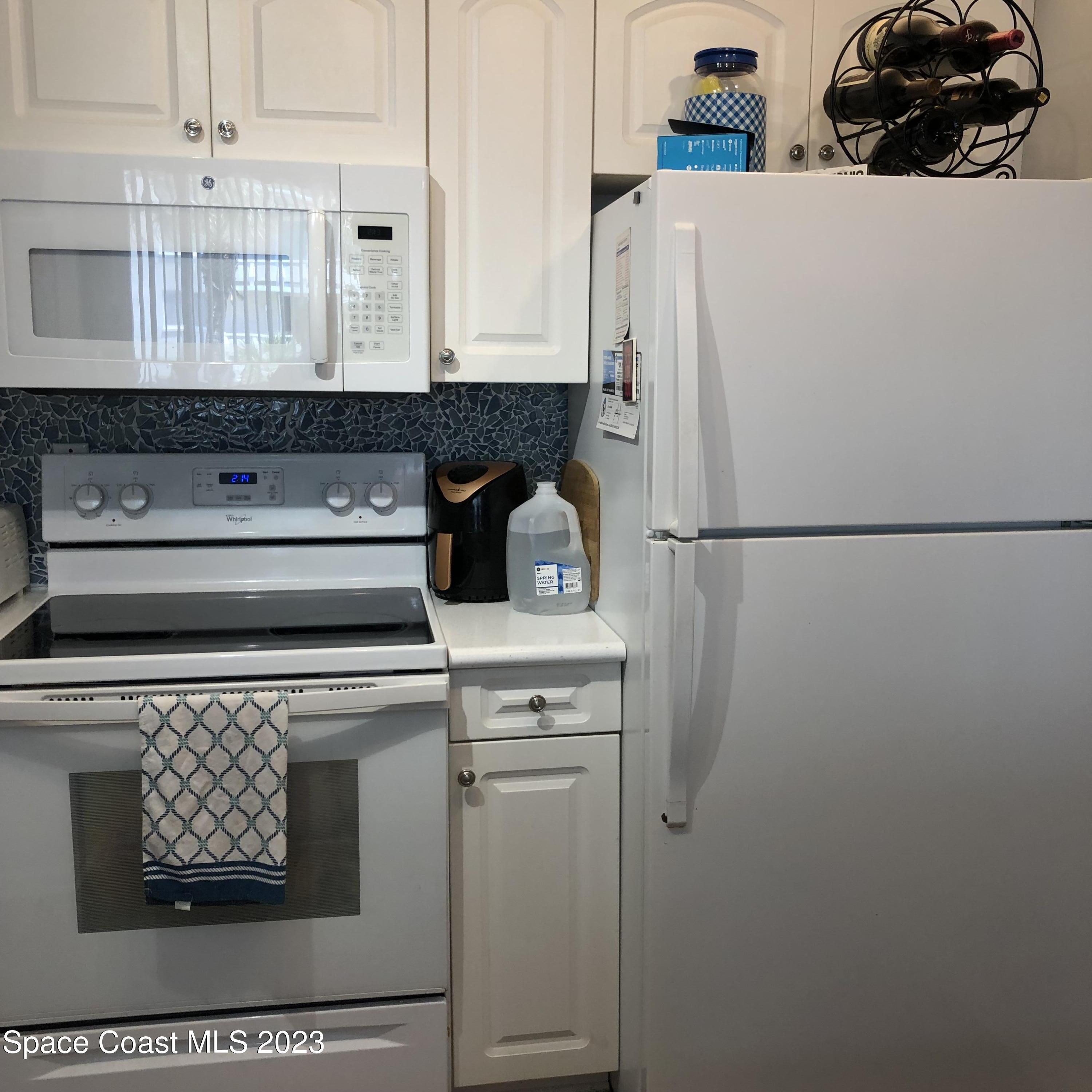 2020 North Atlantic Avenue, Unit 408S Cocoa Beach, FL 32931 - Photo 11 of 22 a white refrigerator freezer sitting inside of a kitchen