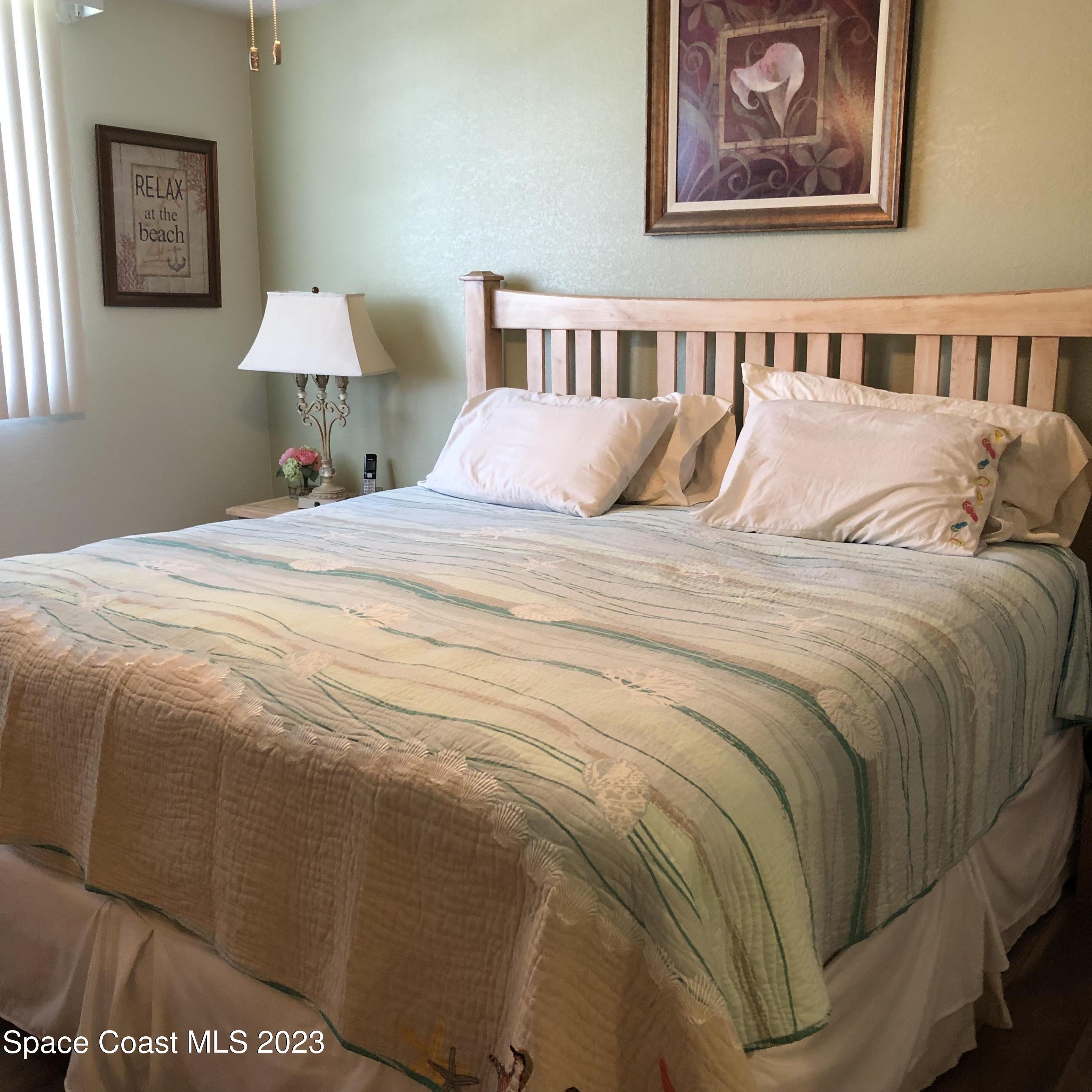 2020 North Atlantic Avenue, Unit 408S Cocoa Beach, FL 32931 - Photo 14 of 22 a bedroom with a bed and a painting on the wall