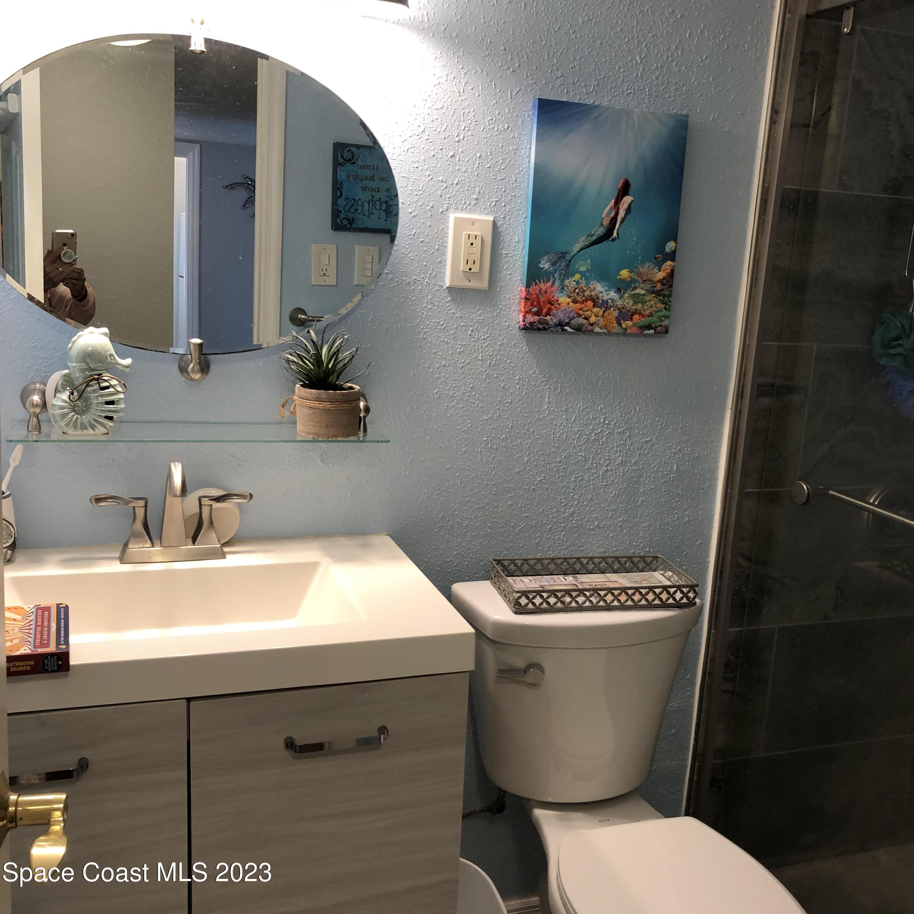 2020 North Atlantic Avenue, Unit 408S Cocoa Beach, FL 32931 - Photo 15 of 22 a bathroom with a toilet a sink and mirror