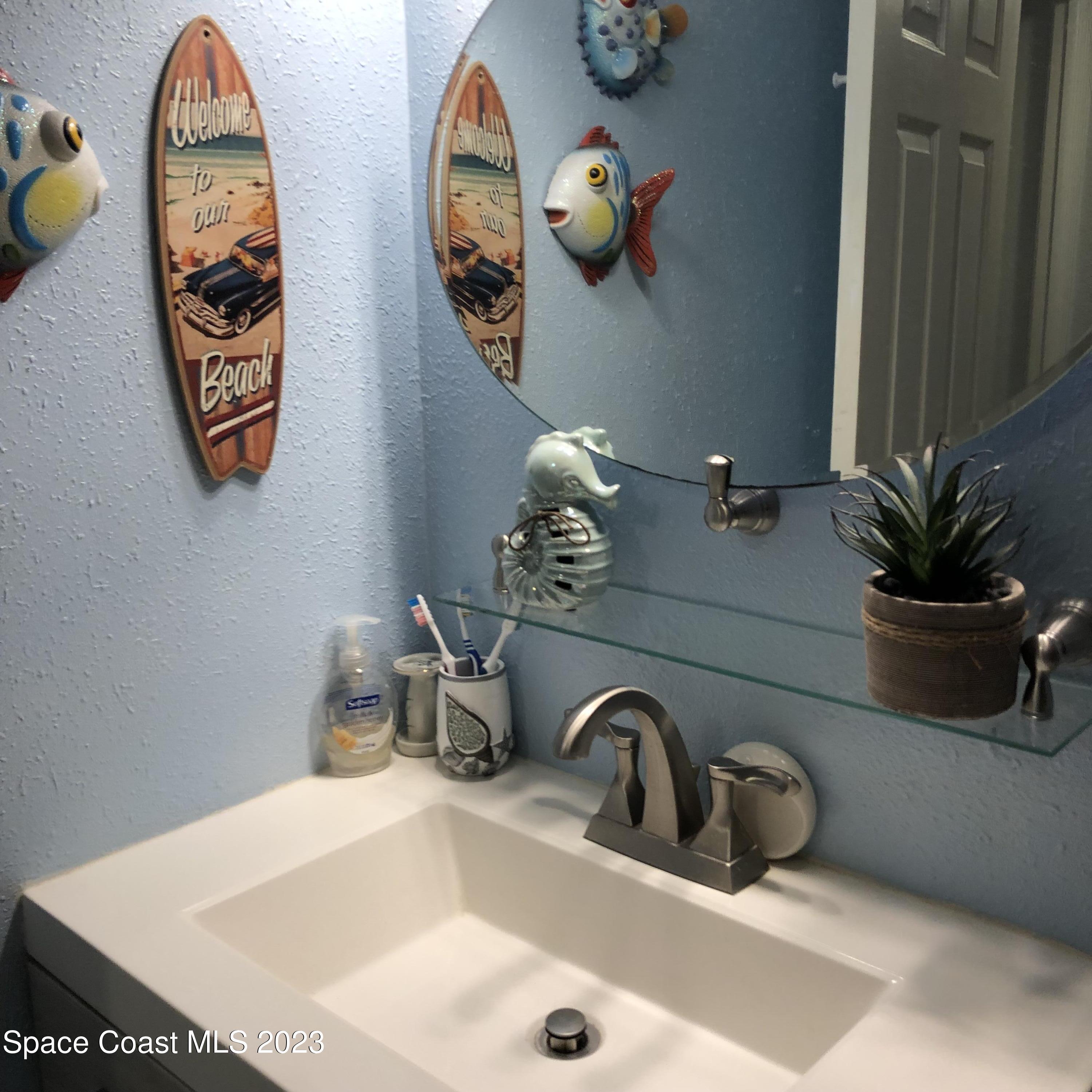 2020 North Atlantic Avenue, Unit 408S Cocoa Beach, FL 32931 - Photo 16 of 22 a bathroom with a sink a mirror and vanity