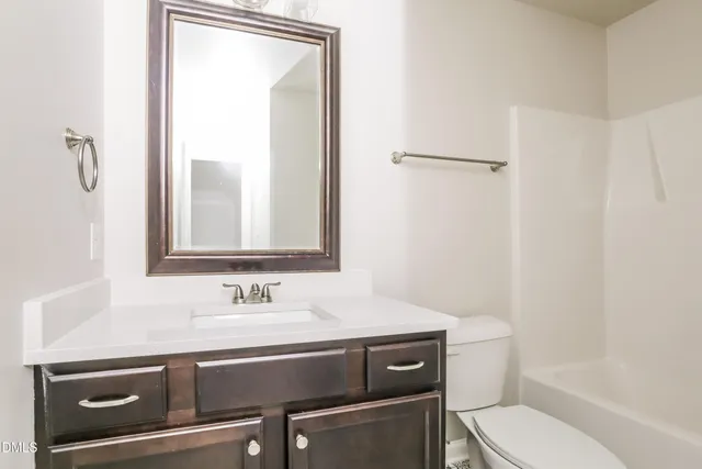 a bathroom with a sink toilet vanity and shower