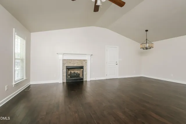 an empty room with windows and fireplace