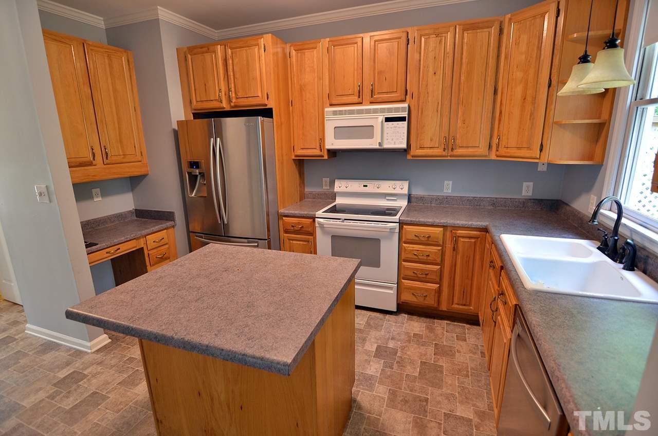 6000 Bunchberry Court Raleigh, NC 27616 - Photo 6 of 25 a kitchen with stainless steel appliances a microwave a sink and a refrigerator