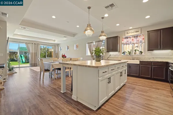 a kitchen with kitchen island granite countertop wooden floors and stainless steel appliances