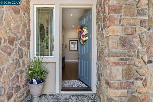 a glass room with a door and a potted plant