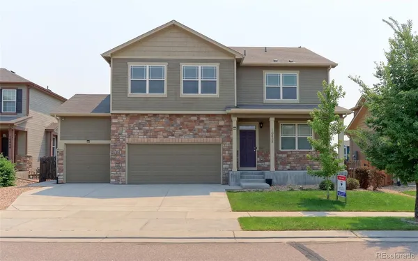 a front view of a house with a garden and yard