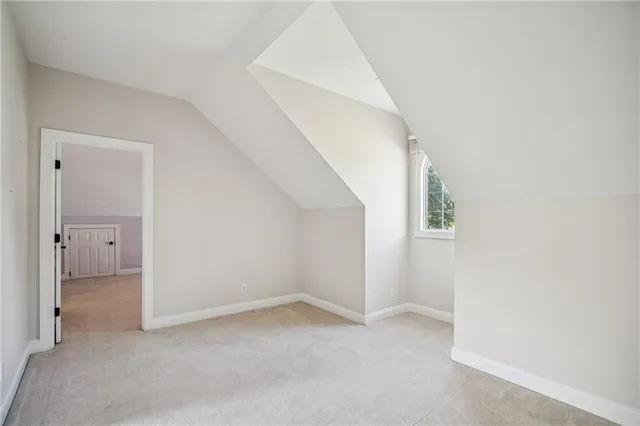 a view of a big yard in front of a brick house with a large tree