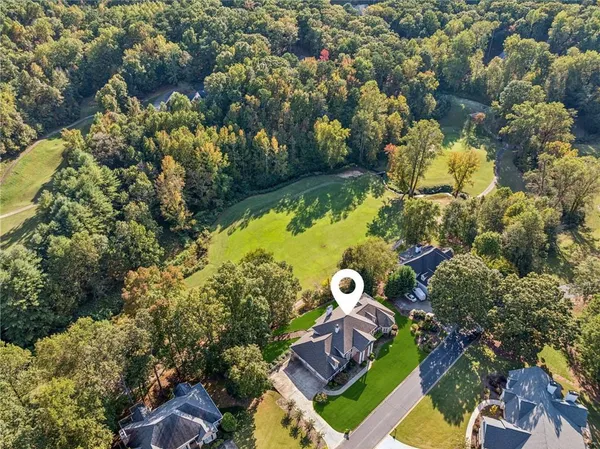 an aerial view of a house with a yard and swimming pool