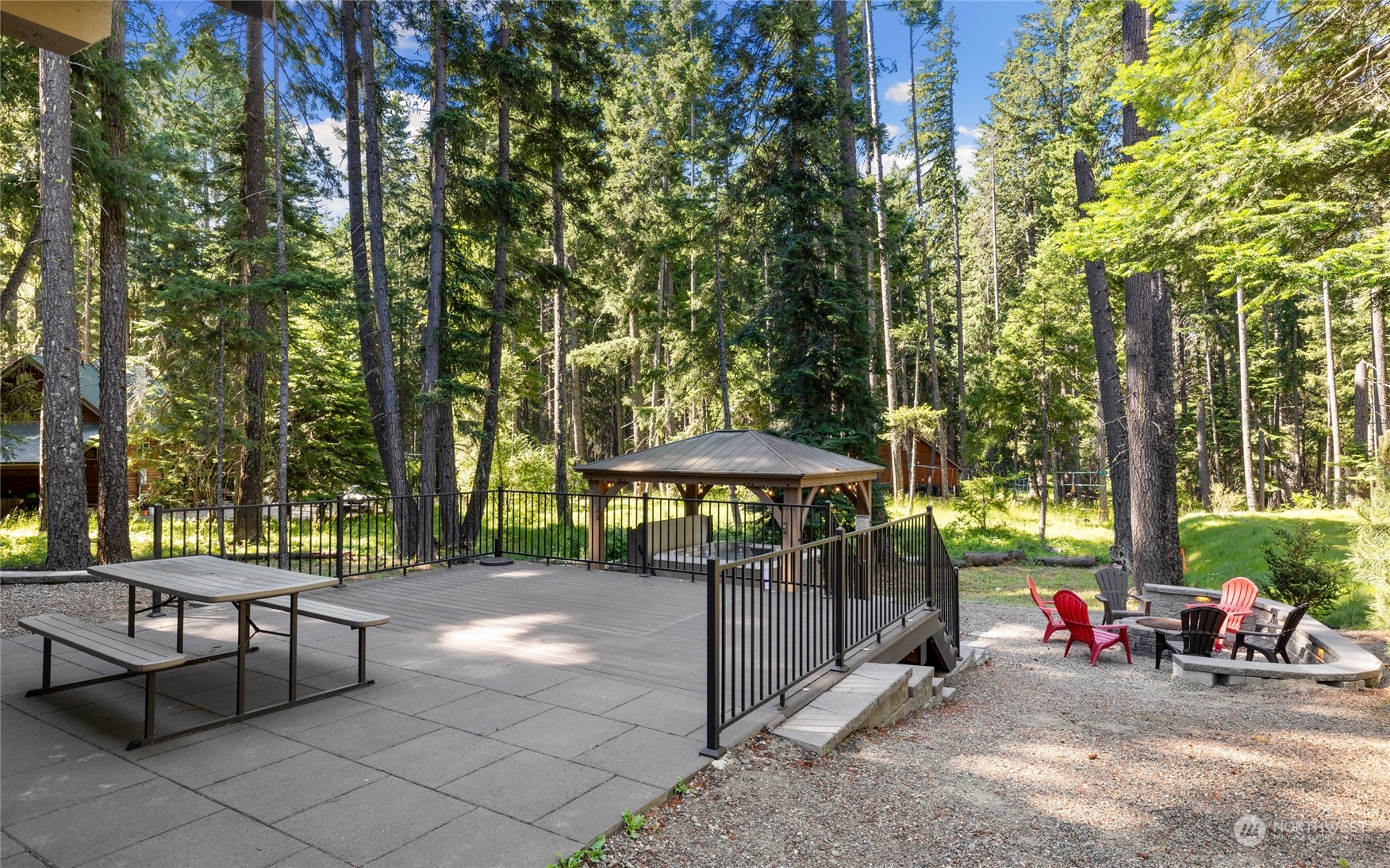 230 Easy Street Ronald, WA 98940 - Photo 3 of 40 a view of a patio with table and chairs under an umbrella with large trees