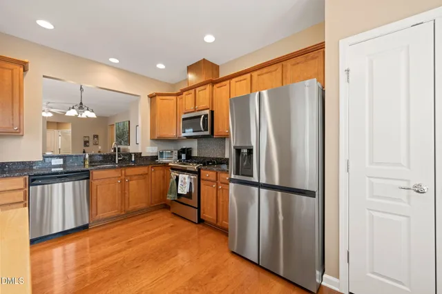 a kitchen with stainless steel appliances granite countertop a refrigerator and a stove top oven