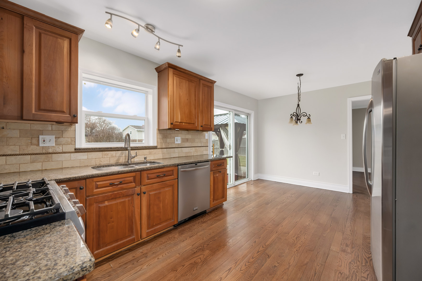 7804 Rohrer Drive Downers Grove, IL 60516 - Photo 7 of 28 a kitchen with stainless steel appliances granite countertop a sink stove and refrigerator