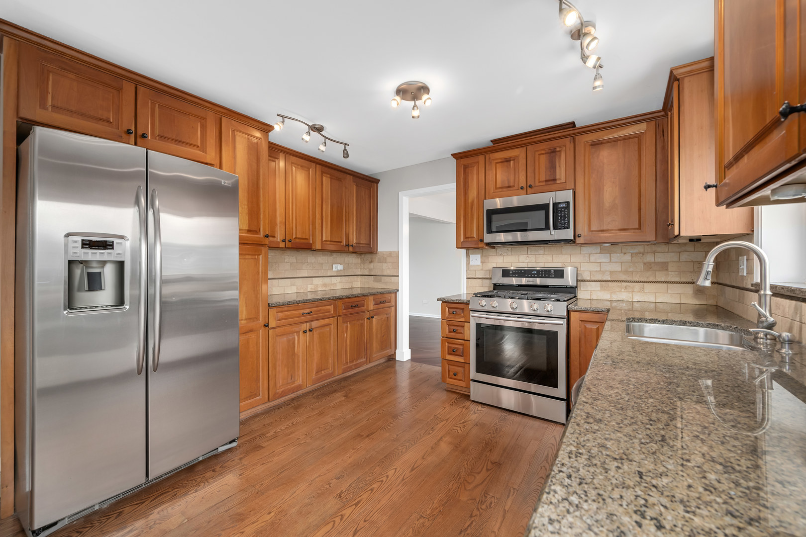 7804 Rohrer Drive Downers Grove, IL 60516 - Photo 9 of 28 a kitchen with granite countertop a refrigerator stove and microwave