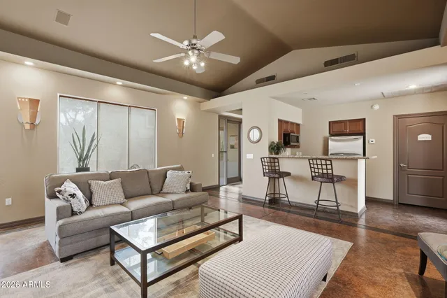 a living room with furniture and a view of kitchen