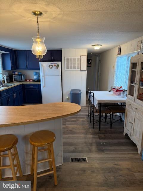 13952 Poplar Grove Road Hagerstown, MD 21742 - Photo 8 of 17 a kitchen with kitchen island a dining table chairs refrigerator and cabinets