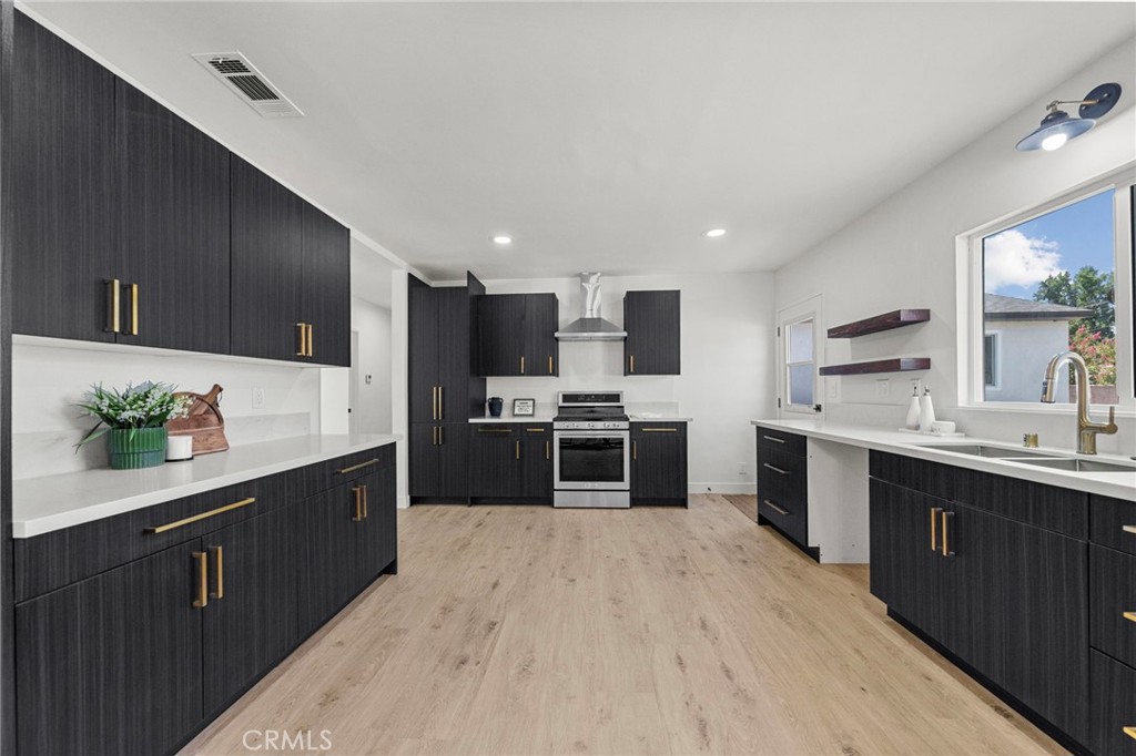 4881 Arlington Avenue Riverside, CA 92504 - Photo 12 of 37 a large kitchen with stainless steel appliances kitchen island granite countertop a sink and cabinets