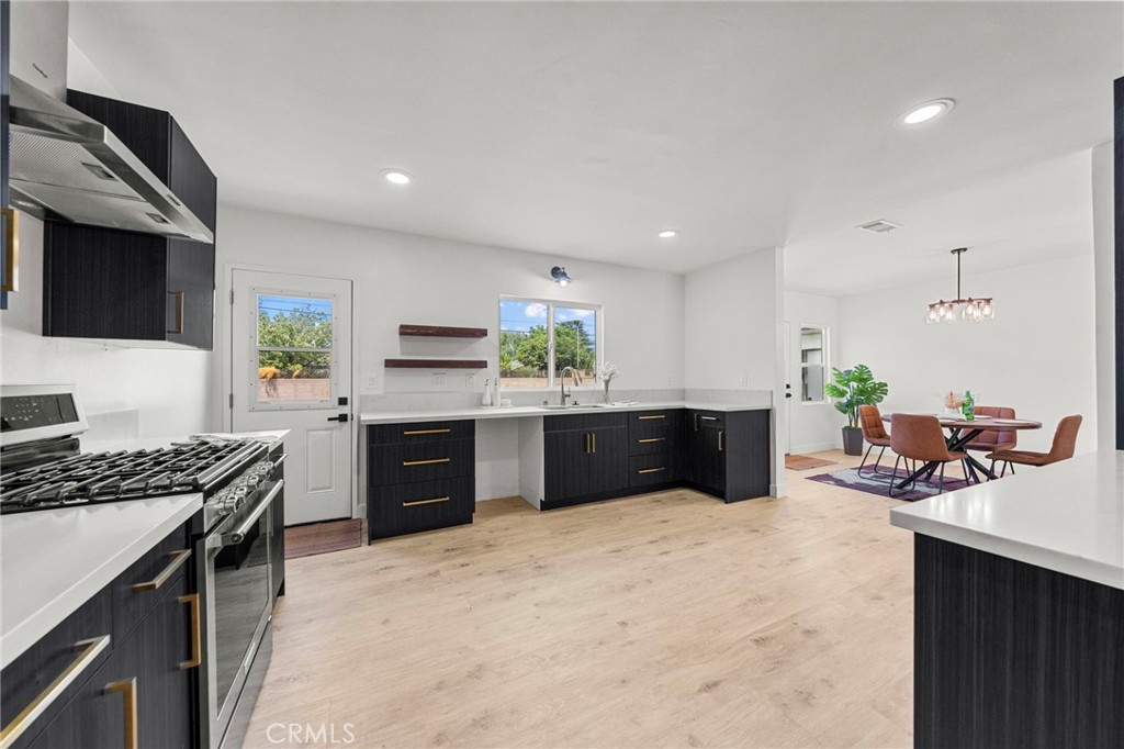 4881 Arlington Avenue Riverside, CA 92504 - Photo 14 of 37 a kitchen with stainless steel appliances kitchen island granite countertop a stove a sink and a microwave